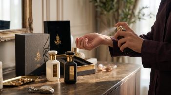Extrait de parfum cost per wear: hand spraying WAJD perfume on the wrist beside WAJD SABAH and LAYL with the LAYL gift box