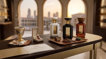 Qatar luxury perfume brands: WAJD SABAH, LAYL and BARR with a bakhoor burner and oud tray, Doha skyline behind